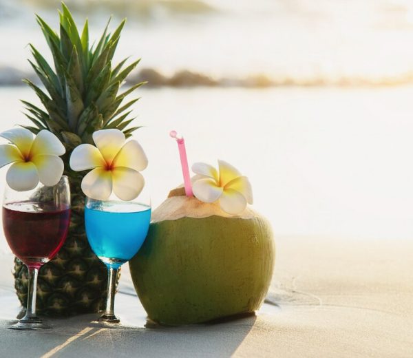 cocktail-glasses-with-coconut-pineapple-clean-sand-beach-fruit-drink-sea-beach_1150-13505